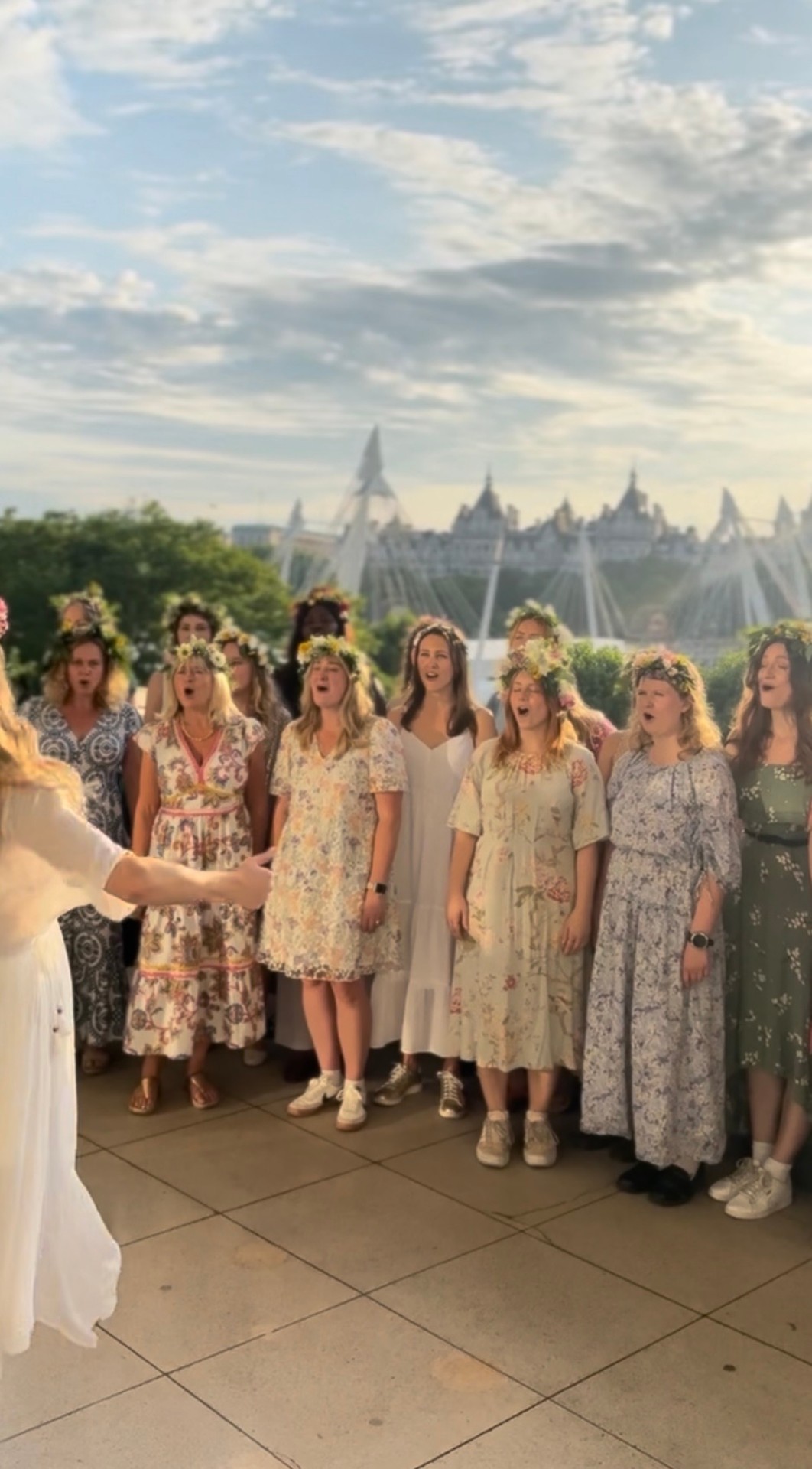 Choir in flower crowns singing outdoors on a rooftop at Midsommar