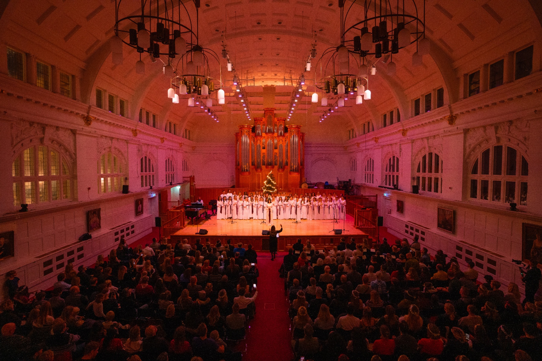 The LondonSwedes Choir performing on stage in a grand London concert hall with a full audience